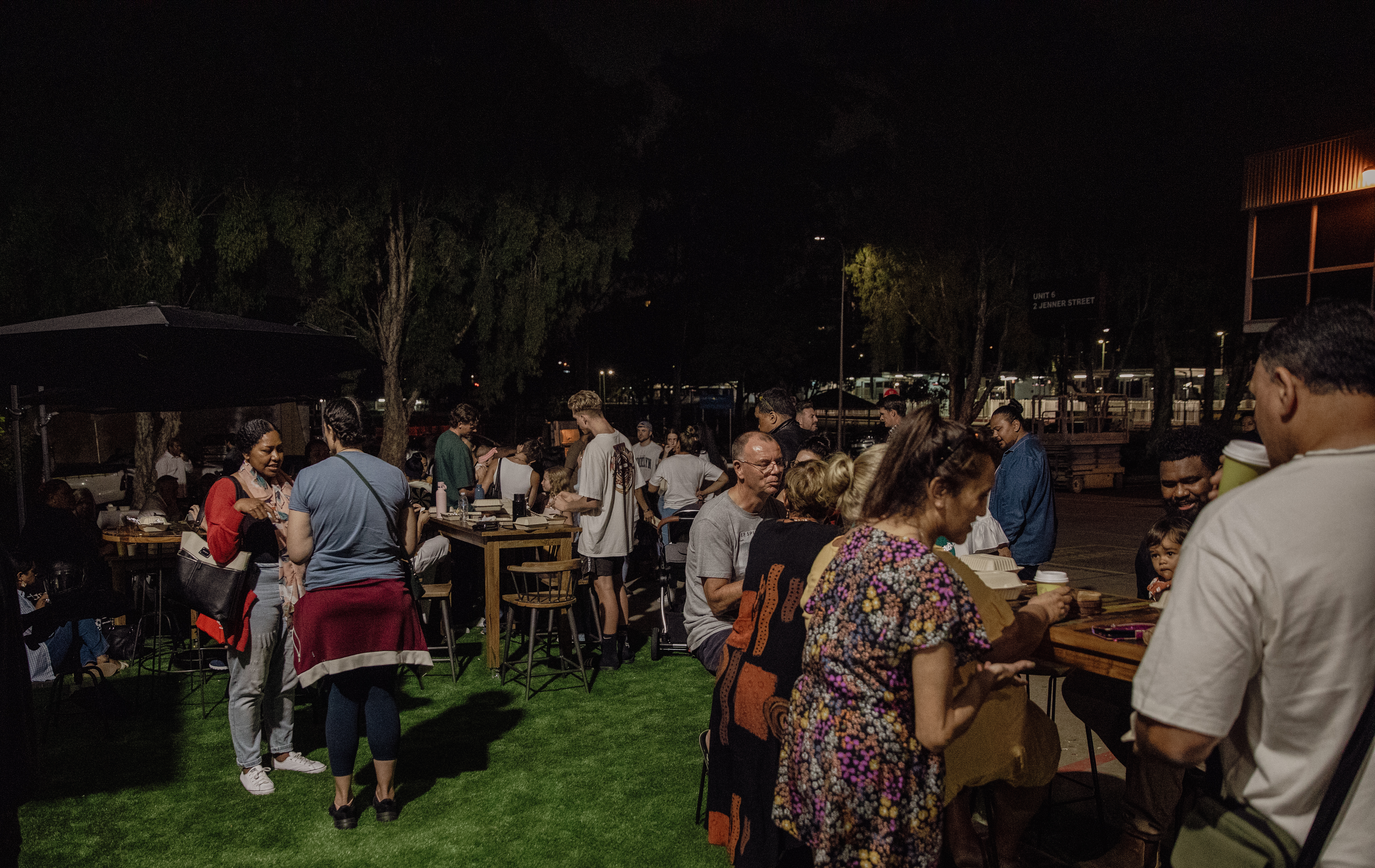 People as part of the Majestic Church community gather for a meal on a lawn.